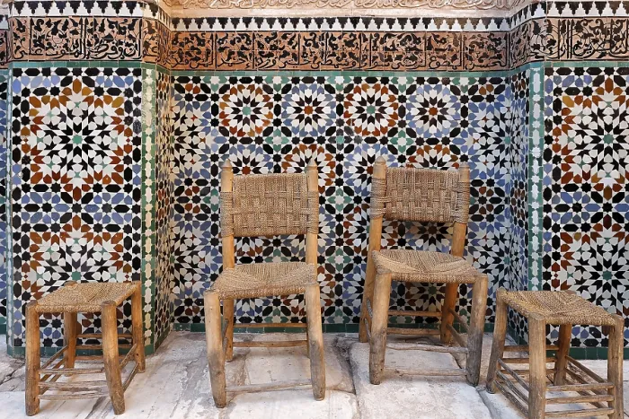 Framed Print : Old wooden chairs and stools in front of a beautiful tiled wall