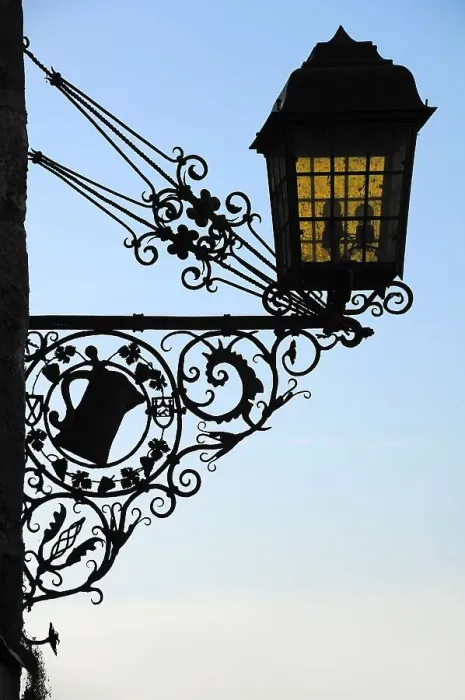 Framed Print : Old, wrought-iron inn sign as a silhouette on the castle building