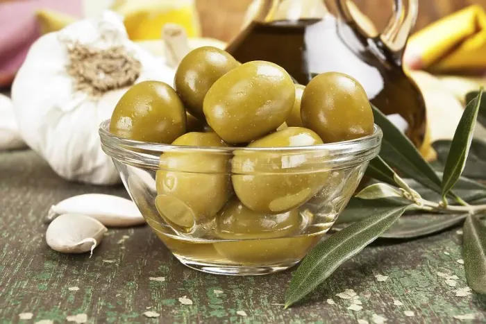 Framed Print : Olives with garlic and a bottle of olive oil
