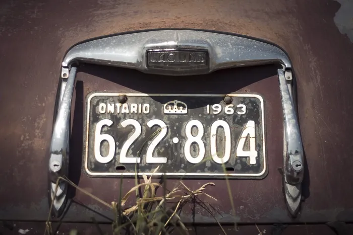 Framed Print : Ontario license plate on a vintage Jaguar car with visible rust and age in rural Huron County