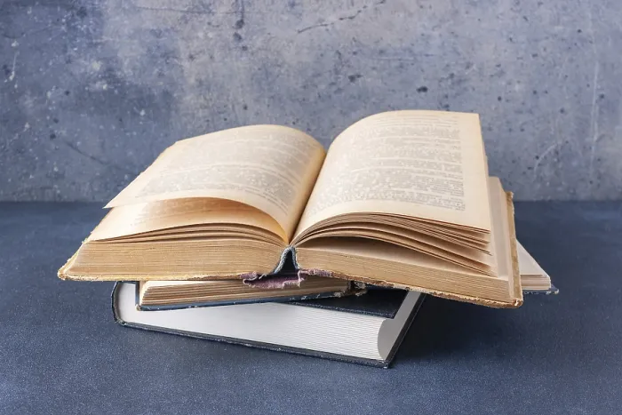 Framed Print : Open vintage book on blue background with copy space