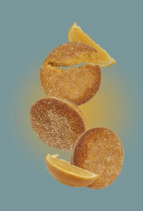 Framed Print : Orange cookies flying on a blue background