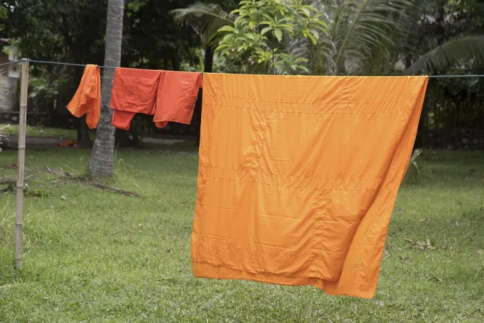 Framed Print : The orange robes of the Buddhist monks are dried on a rope in the Buddhist monastery Framed Print : The orange robes of the Buddhist monks are dried on a rope in the Buddhist monastery