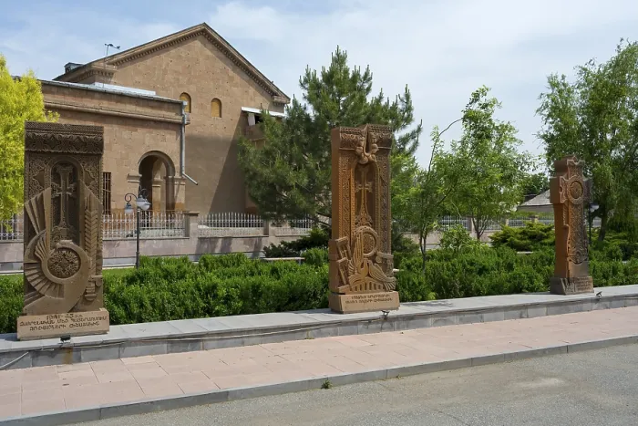 Framed Print : Three ornately decorated khachkars in front of a historic building Framed Print : Three ornately decorated khachkars in front of a historic building