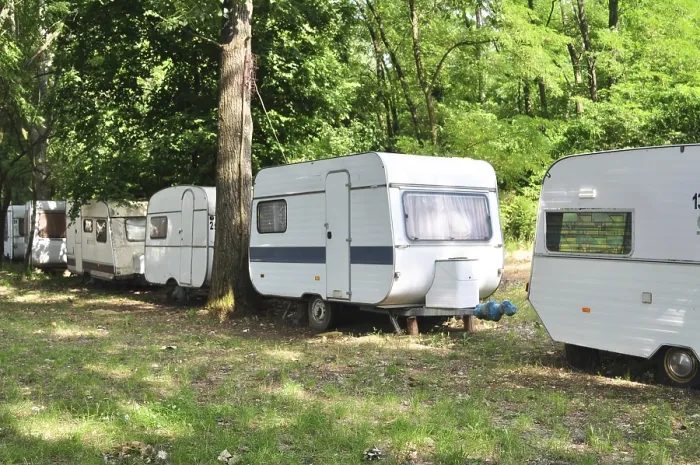 Framed Print : Outdoor forest trailer camp caravan cars behind trees