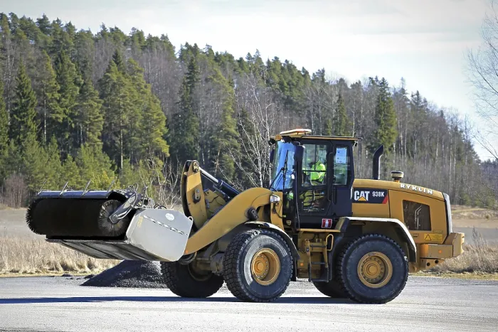 Framed Print : PAIMIO, FINLAND, MARCH 18, 2017: CAT 938K wheel loader and bucket sweeper at work to clean an asphalt yard at spring