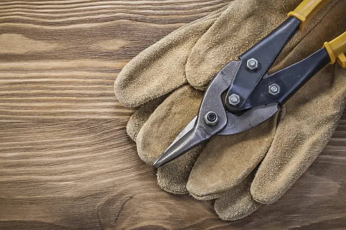 Framed Print : Pair of protective gloves steel cutter on vintage wooden board construction concept