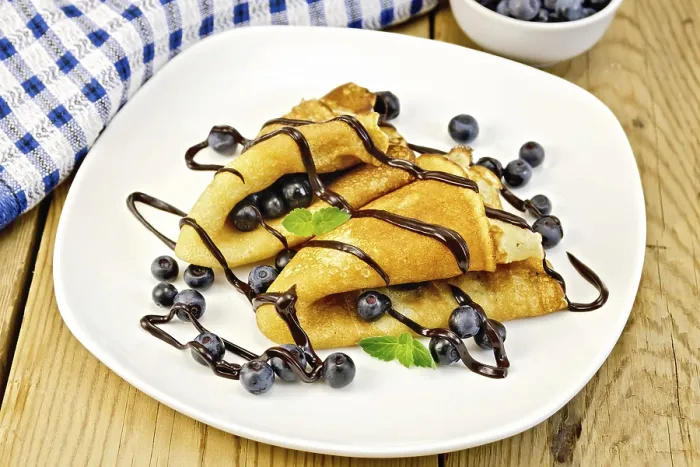 Framed Print : Two pancakes with blueberries, mint and chocolate icing on a plate