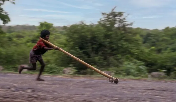 Framed Print : Panning, Tribal boy playing improvised pulley in balle