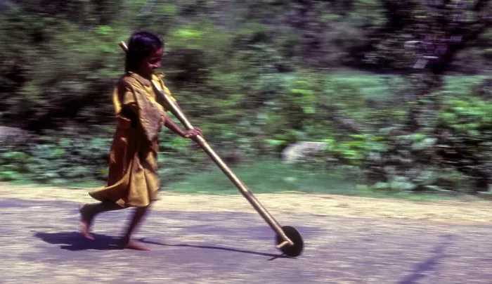 Framed Print : Panning, Tribal girl child playing improvised pulley in balle