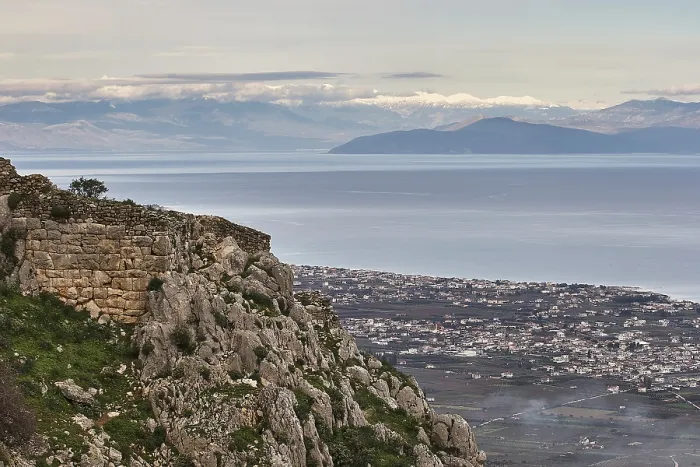 Framed Print : Panoramic view of a coastal town with sea and mountains in the background under a grey sky