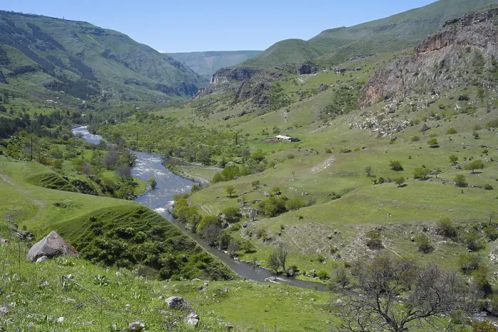 Framed Print : A panoramic view of a green valley with a river surrounded by rolling hills