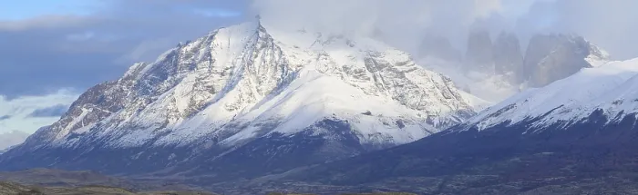 Framed Print : Panoramic view of massive snowy mountains partially covered by clouds