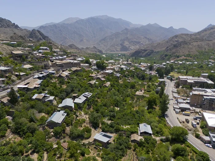Framed Print : Panoramic view of a village along a road amidst green hills and mountains