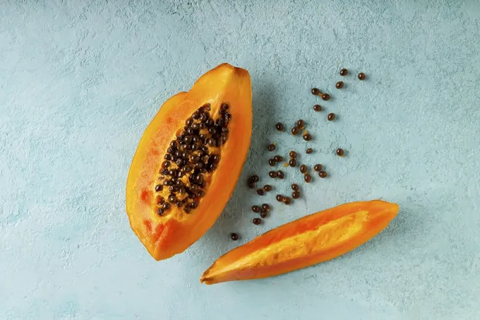 Framed Print : Papaya slices lie on a blue background, copy space