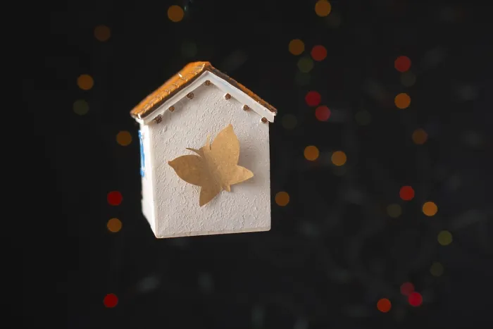 Framed Print : Paper butterfly on a Model house on a bokeh light