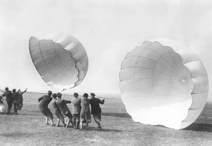 Framed Print : Parachute training in the 1930s. A school for parachuters to be are training and getting to know how a parachute works. They try their parachute and hold them against the wind. Germany 1930s