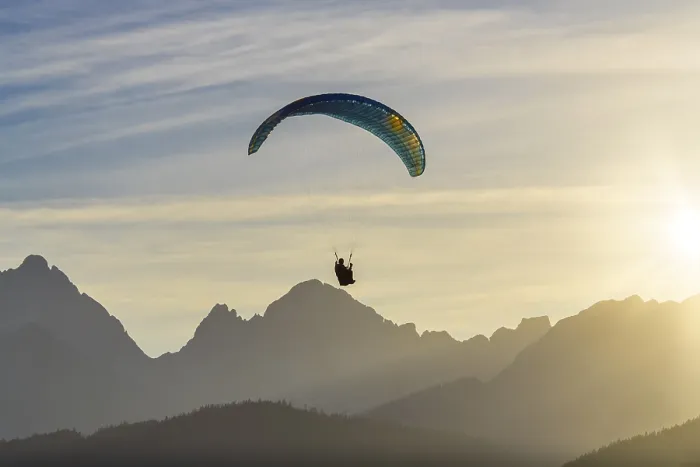 Framed Print : Paraglider over mountain silhouette at sunset with golden rays of light Framed Print : Paraglider over mountain silhouette at sunset with golden rays of light