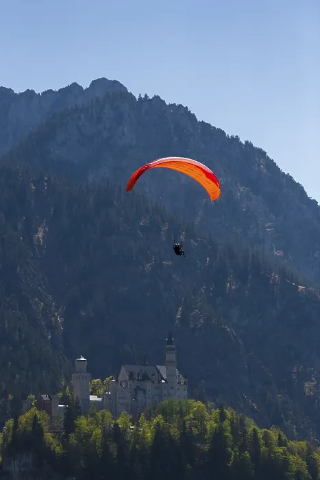 Framed Print : Paraglider over Neuschwanstein Castle in the middle of a natural mountain landscape