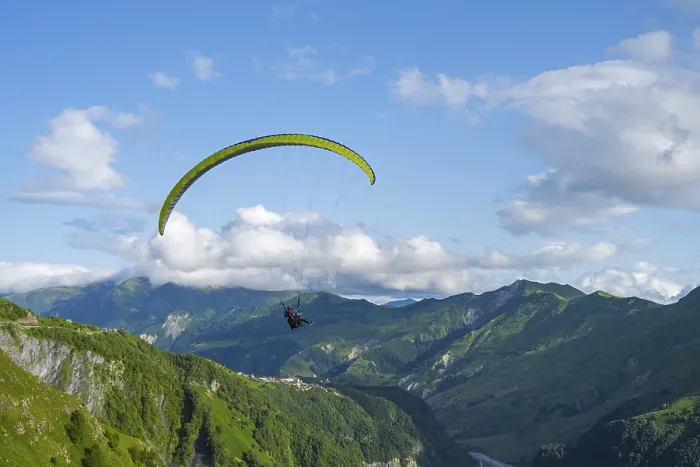 Framed Print : A paraglider in a vast mountain landscape with blue sky and white clouds