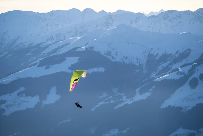 Framed Print : Paragliders flying over snowy mountain peaks in winter in evening light
