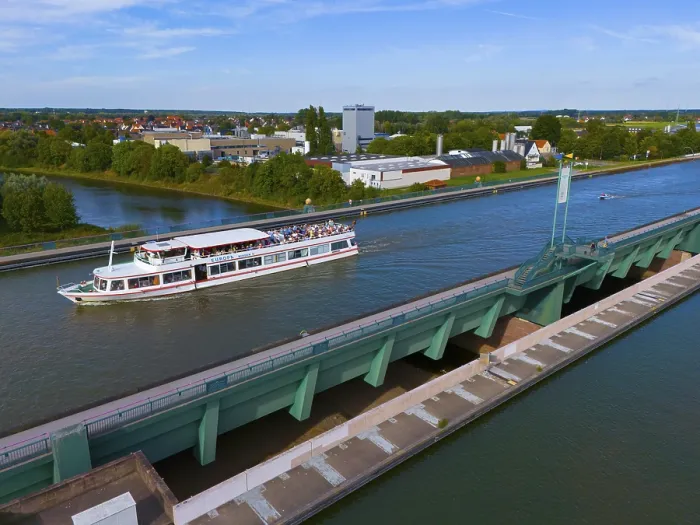 Framed Print : A passenger ship sails on a canal over a large bridge