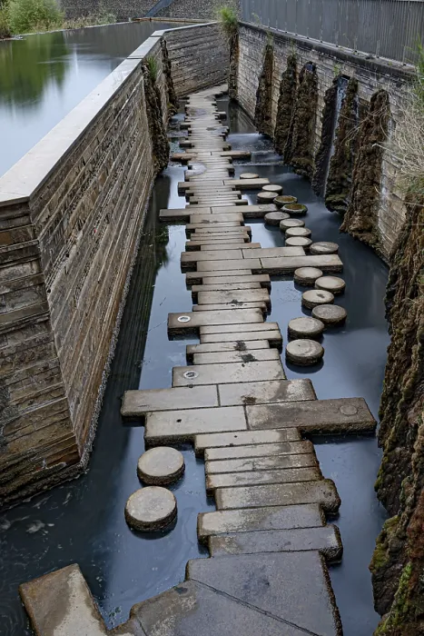 Framed Print : A path of stones leads through a narrow waterway next to a wall Framed Print : A path of stones leads through a narrow waterway next to a wall