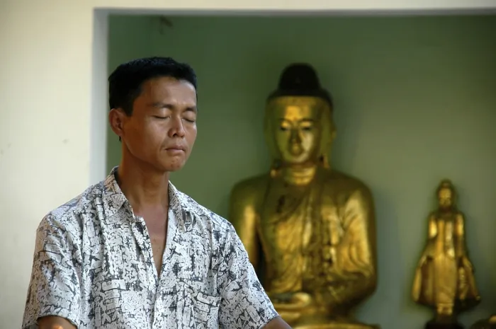 Framed Print : Peace, meditation, man meditating with closed eyes with two Buddha figures