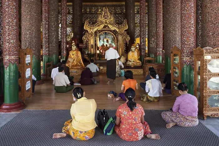 Framed Print : People meditating in front of Buddha statues
