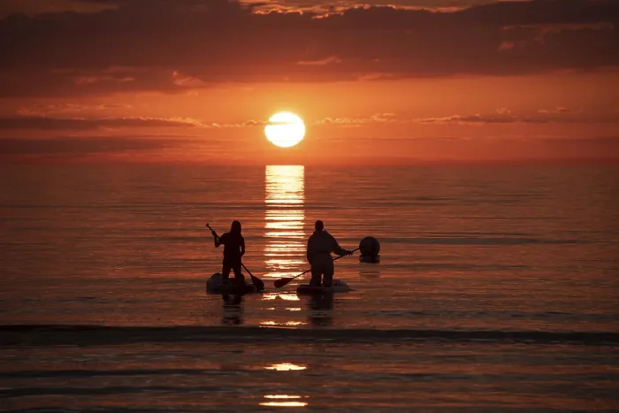 Framed Print : Two people paddling in the calm sea at sunset on stand-up paddle Framed Print : Two people paddling in the calm sea at sunset on stand-up paddle