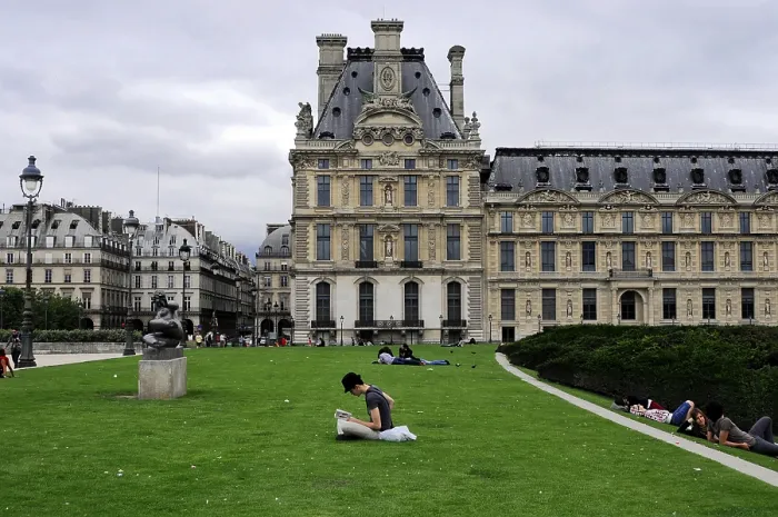 Framed Print : People relaxing on a lawn in front of a historic building in the Louvre complex