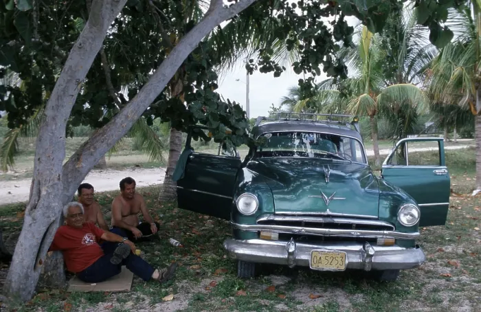 Framed Print : People sitting next to a vintage car