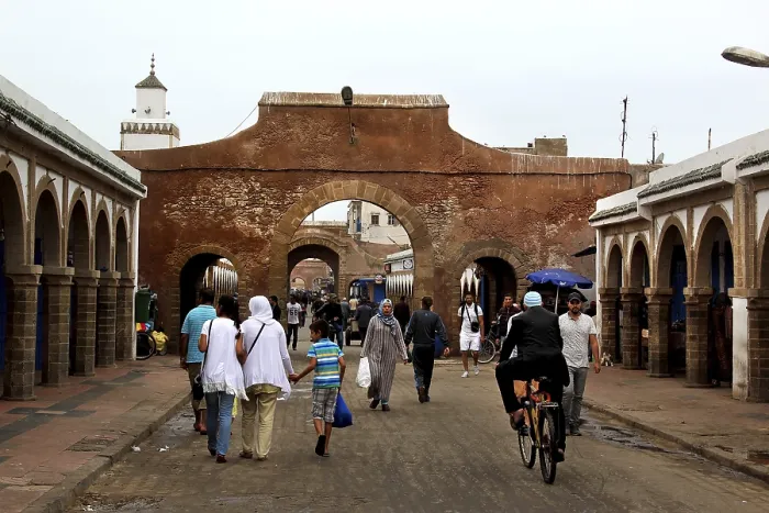 Framed Print : People walk through a historic stone gate in the souk of Essaouira