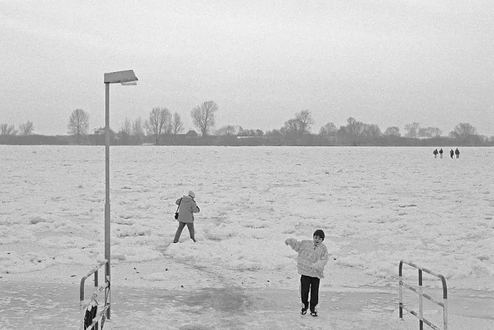 Framed Print : People walk across ice rink, ferry dock