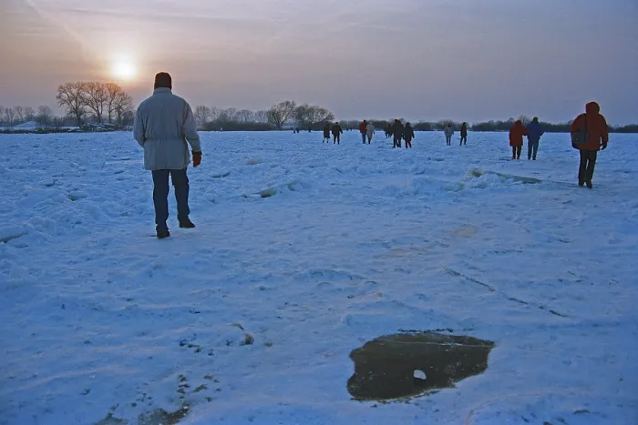 Framed Print : People walk across ice rink, sunset