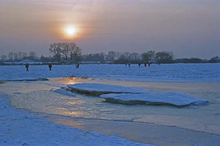 Framed Print : People walk across ice rink, sunset