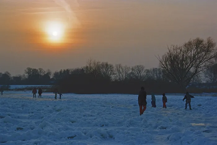 Framed Print : People walk across ice rink, sunset