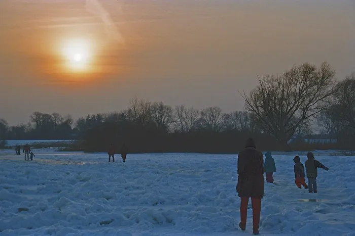Framed Print : People walk across ice rink, sunset