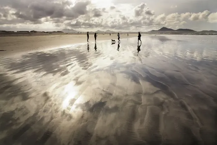 Framed Print : People walking along Famara Beach