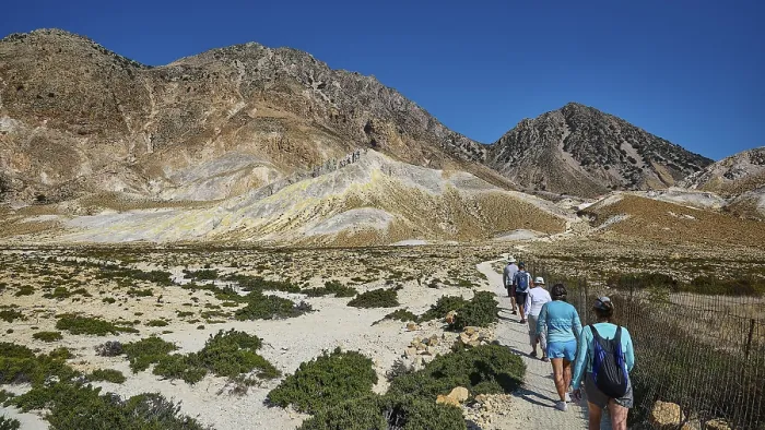 Framed Print : People walking on a path through a mountainous landscape under a clear sky