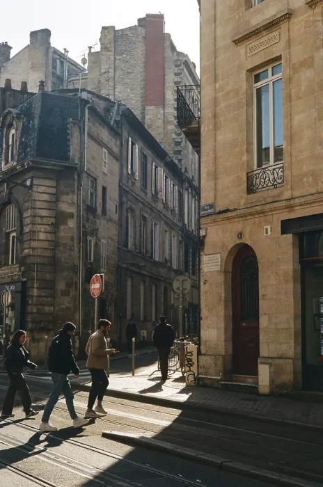 Framed Print : People walking along tram tracks in a sunlit street with classic architecture Framed Print : People walking along tram tracks in a sunlit street with classic architecture