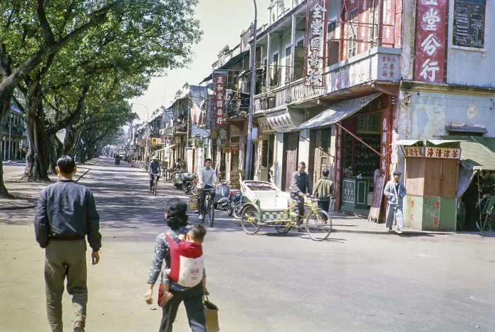 Framed Print : People walling and cycles in tree lined street with small shops Framed Print : People walling and cycles in tree lined street with small shops