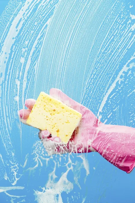 Framed Print : Person cleans glass with sponge on blue background