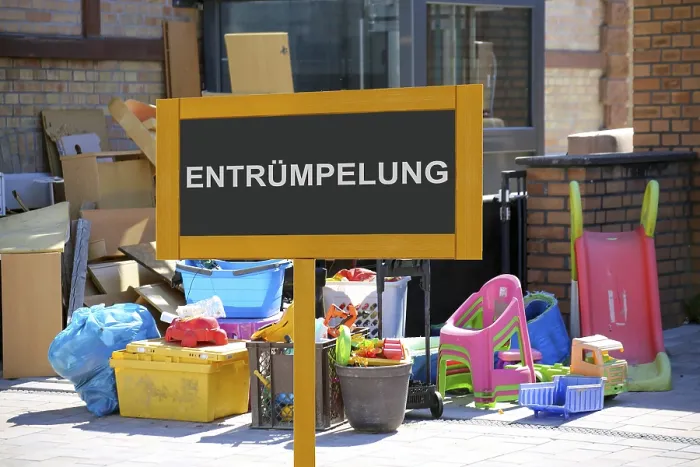 Framed Print : (Photomontage) Sign with the inscription ENTRUMPELUNG vor Sperrmull at a residential building (Photomontage)