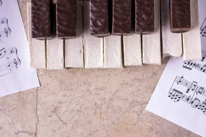 Framed Print : Piano lined with bitten off marshmallows on a beige background