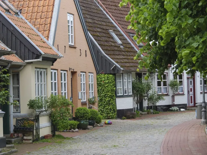 Framed Print : Picturesque half-timbered houses on a cobbled lane with many plants and decorations