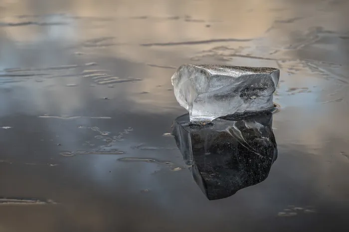 Framed Print : A piece of ice lies on the frozen surface of a lake in which clouds are reflected Framed Print : A piece of ice lies on the frozen surface of a lake in which clouds are reflected