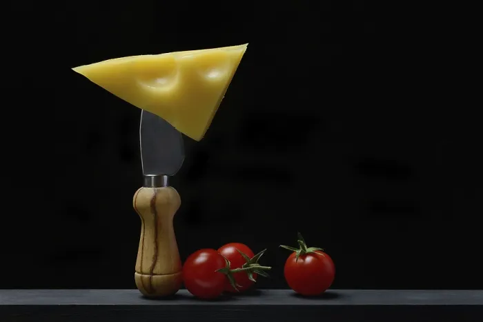 Framed Print : A piece of Swiss Emmental cheese on a cheese knife