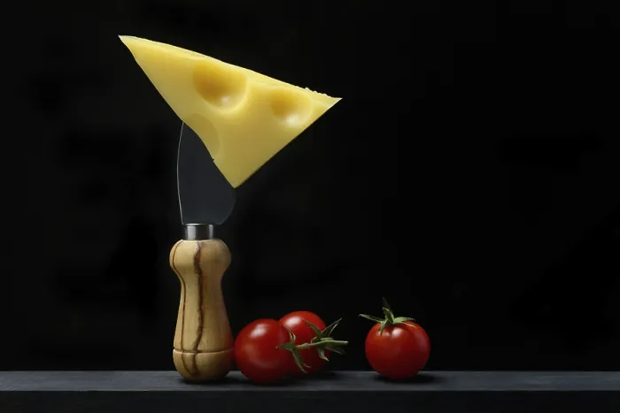 Framed Print : A piece of Swiss Emmental cheese on a cheese knife