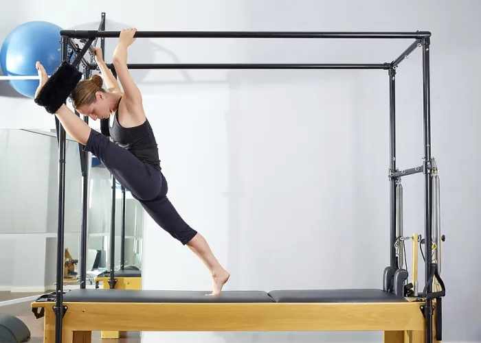 Framed Print : Pilates woman in cadillac split legs stretch exercise at gym Framed Print : Pilates woman in cadillac split legs stretch exercise at gym